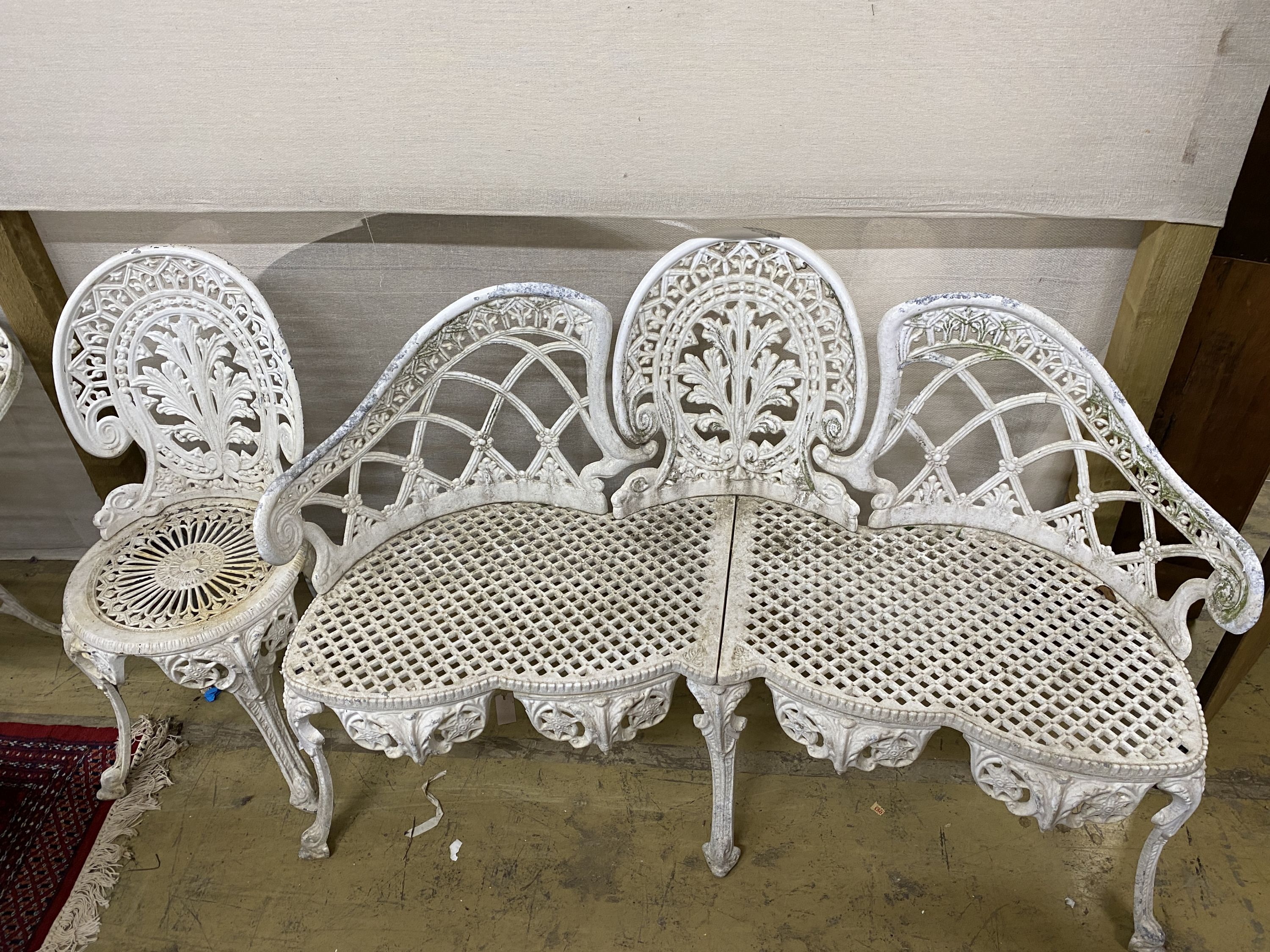 A five piece white painted metal alloy garden suite comprising two benches, length 137cm, pair of chairs and a table, length 141cm